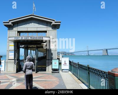 Stazione di attracco del Gate B del San Francisco Ferry Building per i traghetti per la contea di Marin e Treasure Island con Bay Bridge sullo sfondo. Foto Stock