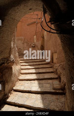 Uno stretto sentiero a gradoni all'interno di Ksar Ghardaia, uno dei 5 insediamenti fortificati tradizionali nella valle di Mzab. Provincia di Ghardaia. Sahara settentrionale. Algeria Foto Stock