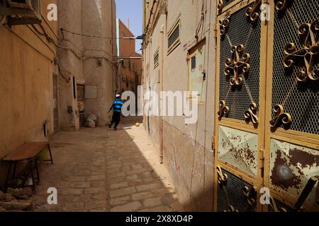 Un bambino che corre attraverso le abitazioni tradizionali all'interno di Ksar Gharddaia, uno dei 5 insediamenti fortificati nella valle di Mzab. Provincia di Ghardaia. Sahara settentrionale. Algeria Foto Stock