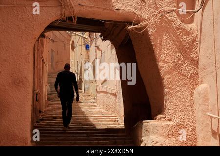 Un uomo che cammina all'interno di Ksar Ghardaia, uno dei 5 insediamenti fortificati tradizionali nella valle di Mzab. Provincia di Ghardaia. Sahara settentrionale. Algeria Foto Stock