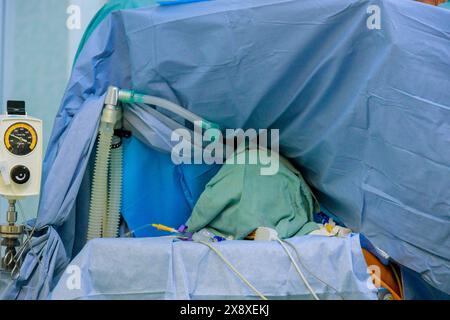 Il medico che esegue l'intervento chirurgico è in corso di esecuzione del paziente in sala operatoria Foto Stock