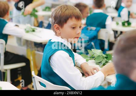 un carino sittimg per bambini a scuola. primo settembre. giornata della conoscenza Foto Stock