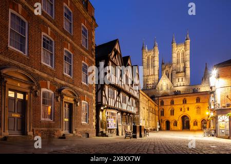 Night falls at Castle Hill in Lincoln, England. Lincoln Cathedral looms in the distance. Foto Stock