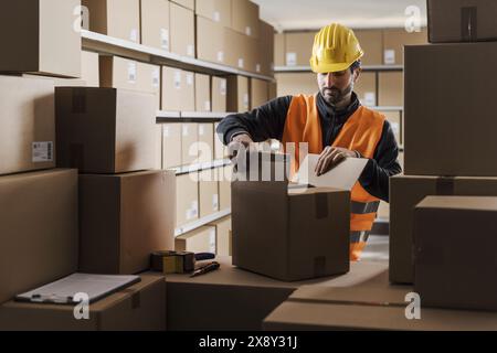 Magazziniere che prepara un pacchetto per il concetto di spedizione, logistica e commercio Foto Stock