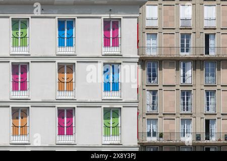 Le Havre - Vista della facciata con finestre decorate con smileys colorati come parte di Un'estate a le Havre, in un complesso alberghiero in stile Perret. Foto Stock