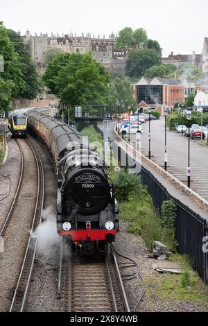 Windsor, Regno Unito. 28 maggio 2024. È stato un piacere vedere la Steam Dream Rail Company Britannia Steam Locomotive alla Windsor & Eton Riverside Station oggi sullo sfondo del Castello di Windsor nel Berkshire. La stazione Windsor & Eton Riverside, classificata Grade II, è stata progettata per la London & South Western Railway come una stazione reale. I passeggeri erano diretti a Norwich per una gita di un giorno. La classe 70000 Britannia costruita nel 1951 è una locomotiva a vapore conservata, di proprietà della Royal Scot Locomotive and General Trust. Crediti: Maureen McLean/Alamy Live News Foto Stock