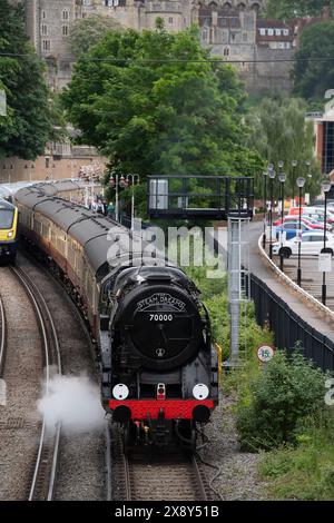 Windsor, Regno Unito. 28 maggio 2024. È stato un piacere vedere la Steam Dream Rail Company Britannia Steam Locomotive alla Windsor & Eton Riverside Station oggi sullo sfondo del Castello di Windsor nel Berkshire. La stazione Windsor & Eton Riverside, classificata Grade II, è stata progettata per la London & South Western Railway come una stazione reale. I passeggeri erano diretti a Norwich per una gita di un giorno. La classe 70000 Britannia costruita nel 1951 è una locomotiva a vapore conservata, di proprietà della Royal Scot Locomotive and General Trust. Crediti: Maureen McLean/Alamy Live News Foto Stock