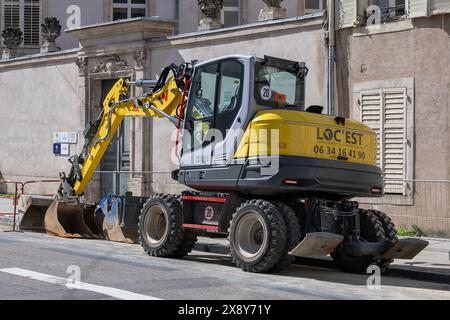 Nancy, Francia - concentrati su un escavatore gommato giallo Wacker Neuson EW100-2 in una strada per lavori stradali. Foto Stock