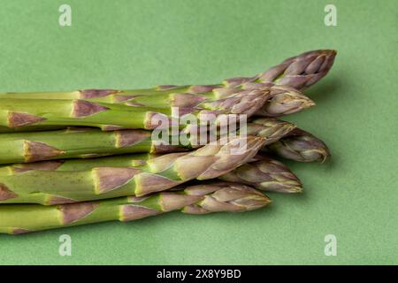 Punte di asparagi verdi su sfondo verde Foto Stock