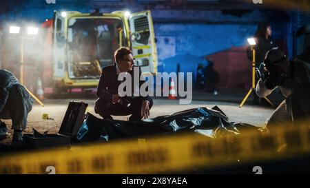 Nastri non incrociare che limitano l'accesso alla scena del crimine in una Back Alley. Detective che ispeziona il corpo e pensa al movente dell'assassino. Investigatore intelligente che mette in relazione il caso a un serial killer Foto Stock