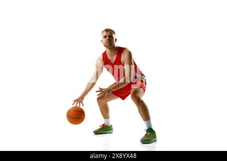 Ritratto dinamico di un giovane atleta professionista, pronto a segnare gol su sfondo bianco. Foto Stock