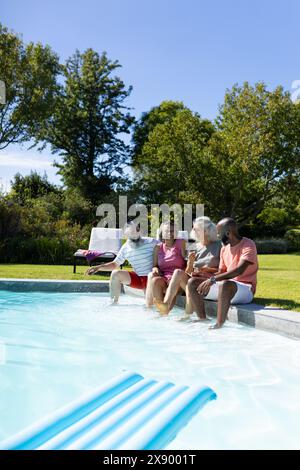 All'aperto, diversi amici anziani che ridono in piscina e condividono battute Foto Stock