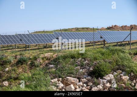 I moduli fotovoltaici a terra sono costruiti e protetti da recinzioni di animali e persone Foto Stock