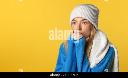 Giovane donna con maglione blu e berretto bianco Foto Stock