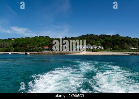 Traghetto che parte dal porto di Herm Island e fa ritorno ai passeggeri della gita di un giorno alle Isole del Canale di Guernsey in un incantevole giorno di maggio con cielo blu e mare Foto Stock