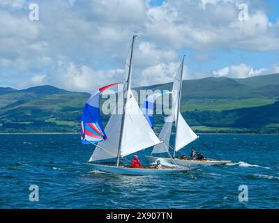 Gara di dingy in una regata il 27 maggio 2024 nello stretto di Menai da Beaumaris nel Galles del Nord, Regno Unito Foto Stock