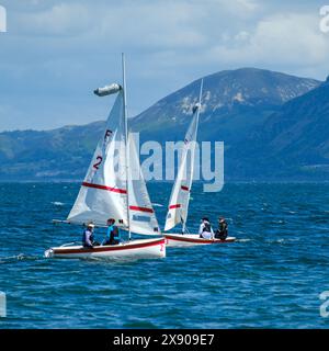 Gara di dingy in una regata il 27 maggio 2024 nello stretto di Menai da Beaumaris nel Galles del Nord, Regno Unito Foto Stock