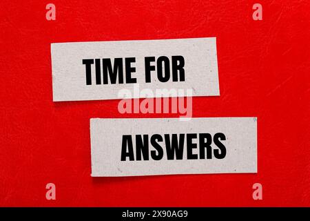 Tempo per le risposte parole scritte su pezzi di carta con sfondo rosso. Simbolo tempo concettuale per le risposte. Copia spazio. Foto Stock