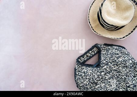 Comodo cappello estivo in paglia da spiaggia con strisce nere e borsa in vimini sullo sfondo dello spazio di copia beige Foto Stock