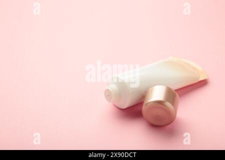 Flacone con etichetta vuota della vista dall'alto per la cura della pelle del viso con coperchio aperto su sfondo rosa. Spazio per il testo Foto Stock