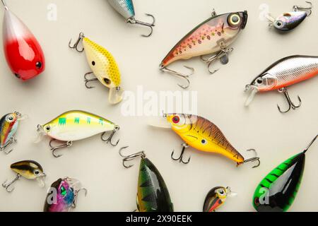 Nikolaev, Ucraina - 8 luglio 2022: Acquitrini colorati, wobbler, spinner, su sfondo grigio, diverse esche da pesca. Vista dall'alto. Foto Stock