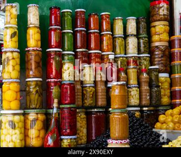 Immagine del cibo conservato in vasetti impilati verticalmente - olive, limoni, cipolle, peperoni - in un mercato in Marocco 7 Foto Stock