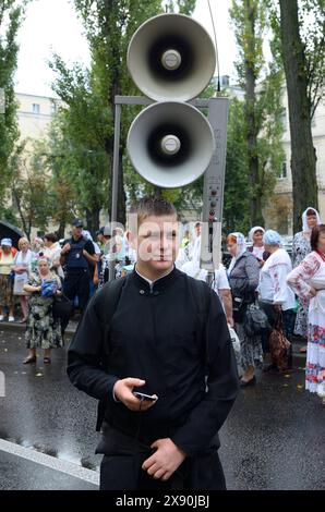 Giovane monaco ortodosso che porta altoparlanti in strada. Chiesa Ucraina Ortodossa del Patriarcato di Kyiv, processione incrociata. Kiev, Ucraina Foto Stock