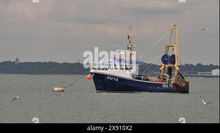 Calshot, hampshire, Regno Unito. 24 maggio 2024. La vista dalla spiaggia di Calshot si affaccia sul Solent verso Southampton e presenta una barca da pesca costiera. Foto Stock