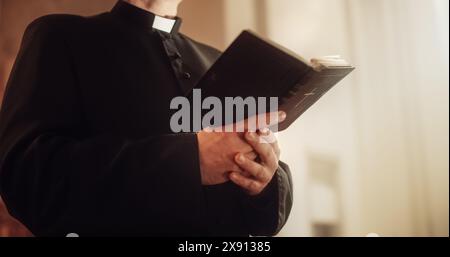 Nella Chiesa cristiana: Primo piano della Bibbia, Vangelo di Gesù. Il Ministro guida la Congregazione nella preghiera e legge dal Sacro Libro, sacerdote che fornisce orientamento, fede, speranza alle persone. Foto Stock