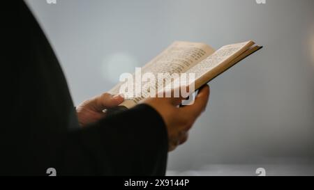 Nella Chiesa cristiana: Primo piano della Bibbia, Vangelo di Gesù. Il Ministro guida la Congregazione nella preghiera e legge dal Sacro Libro, sacerdote che fornisce orientamento, fede, speranza alle persone. Foto Stock