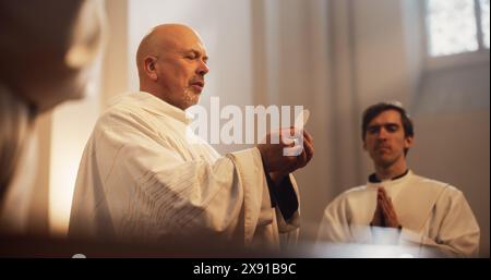 Ministri che guidano l Eucaristia, la Sacra cerimonia cristiana della condivisione del pane e del vino per ricordare il sacrificio di Gesù, offrendo orientamento e sostegno. Santa Comunione, Santa messa Divina, la cena del Signore Foto Stock