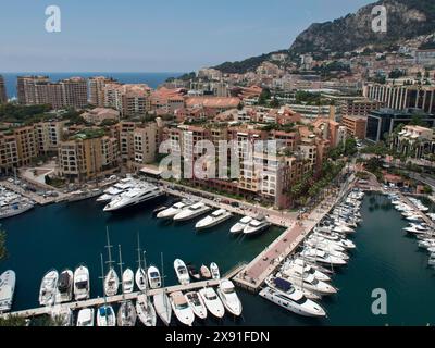 Porto con molti yacht, circondato da edifici lungo la costa, sotto un cielo limpido in estate, barche e yacht nel mare blu di fronte a una città Foto Stock