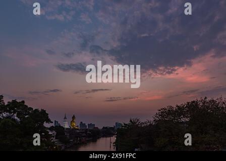 Un'immagine della grande statua di Buddha al tempio Wat Paknam Bhasicharoen, vista da lontano, al tramonto. Foto Stock