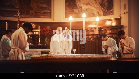 L'Eucaristia nella grande Chiesa: I Ministri della fede cristiana guidano la cerimonia che prevede la condivisione del pane e del vino in onore di Gesù Cristo. Santa Comunione, Santa messa Divina, cena del Signore sull'altare Foto Stock