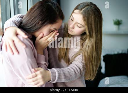 Ragazza adolescente consolante la sua triste amica nella sua camera da letto Foto Stock