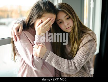 Ragazza adolescente consolante la sua triste amica nella sua camera da letto Foto Stock