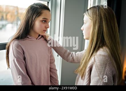 Ragazza adolescente consolante la sua triste amica nella sua camera da letto Foto Stock