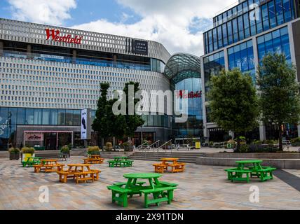 plaza all'aperto con tavoli da picnic verdi davanti all'ingresso del complesso commerciale Westfield sotto un cielo nuvoloso Foto Stock