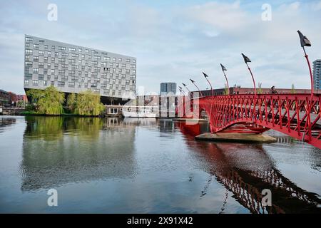 Paesi Bassi, Amsterdam - 10 aprile 2024: Vista dell'iconico edificio moderno conosciuto come la balena e il ponte rosso a Sporenburg, Docklands orientali Foto Stock