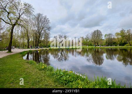 Paesi Bassi, Amsterdam - 10 aprile 2024: Campo di erba e stagno a Vondelpark. È un parco urbano pubblico di 47 ettari. Foto Stock