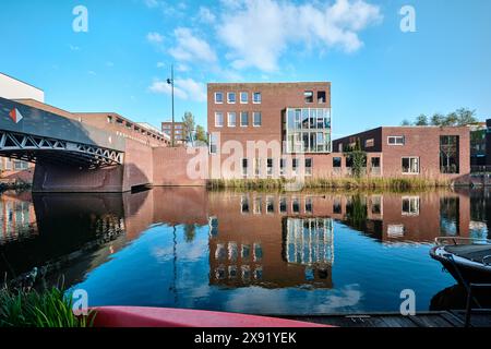 Paesi Bassi, Amsterdam - 10 aprile 2024: Edifici residenziali e architettura moderna in mattoni con vista sui canali nel quartiere di Ijburg Foto Stock