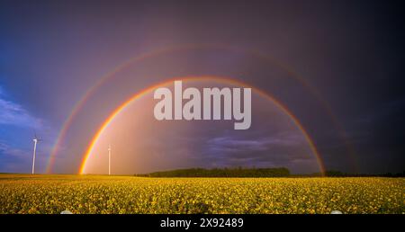 Doppio arcobaleno sulle turbine eoliche in ambiente rurale incentrato sulla natura e sulle energie rinnovabili Foto Stock