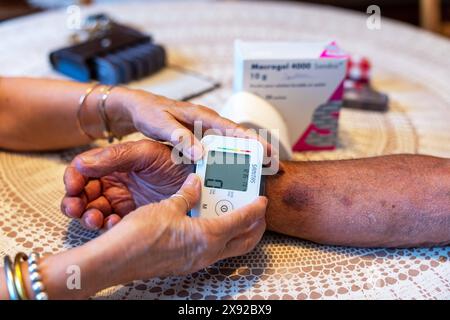 Infermiera per la cura a domicilio di un 90enne, che prende pressione. Pressione arteriosa 016739 044 Foto Stock