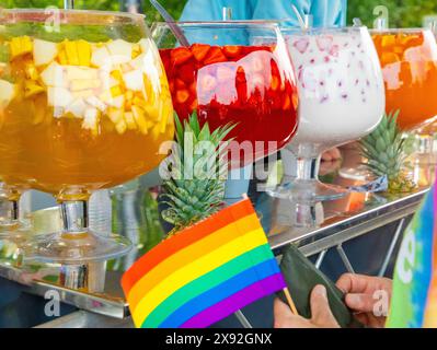 fila di grandi ciotole di vetro piene di bevande colorate e diversi tipi di frutta. drink punch con ananas, fragole e opzione a base di latte wi Foto Stock