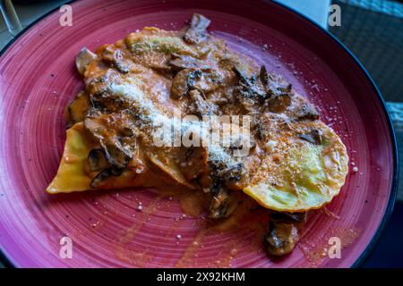 Patate ripiene mediterranee e gnocchi di formaggio con salsa di crema di funghi serviti in un ristorante spagnolo Foto Stock