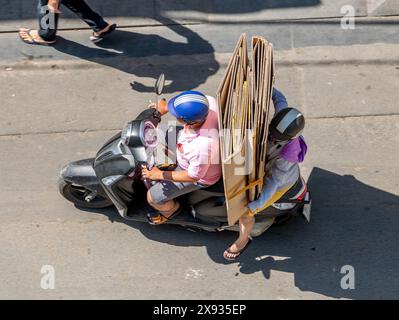 Una coppia sta trasportando cartoni di carta dispiegati su una moto, ho chi Minh, Vietnam. Foto Stock