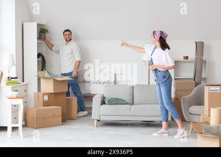 Felice giovane coppia che fa le valigie in camera il giorno del trasloco Foto Stock