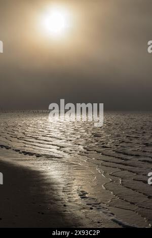 Il sole mattutino risplende attraverso la fitta nebbia che si riflette sulle acque della baia di Biloxi a Front Beach a Ocean Springs, Mississippi Foto Stock