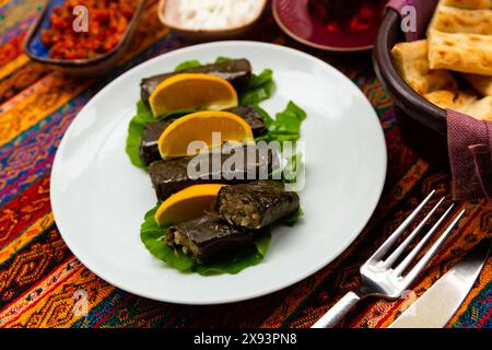 sarma turca da riso avvolto in foglie d'uva servito con limone Foto Stock