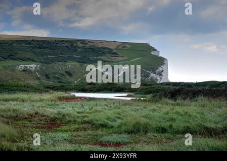 Cuckmere Haven, Regno Unito - 10 settembre 2022: Vista delle Seven Sisters Cliffs nella giornata di sole con nuvole che mostrano scogliere, sentieri con camminatori e giochi d'acqua Foto Stock